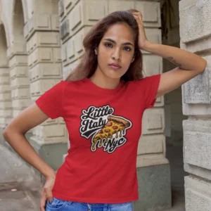 Camiseta para mujer con una porción de pizza y el mensaje "LITTLE ITALY NYC", ideal para amantes de la pizza y Nueva York.