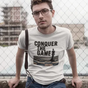 Camiseta de hombre con la imagen de un rey de ajedrez en un tablero y el texto "Conquer the Game".